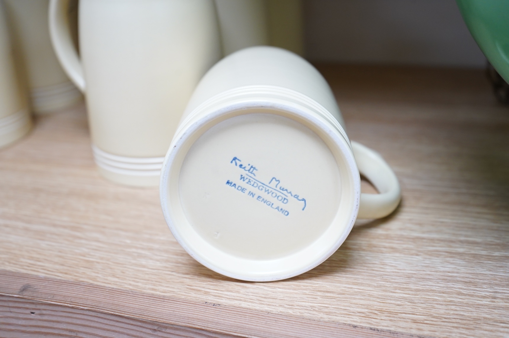 Keith Murray for Wedgwood, a set of eight straw glazed mugs, 12cm high